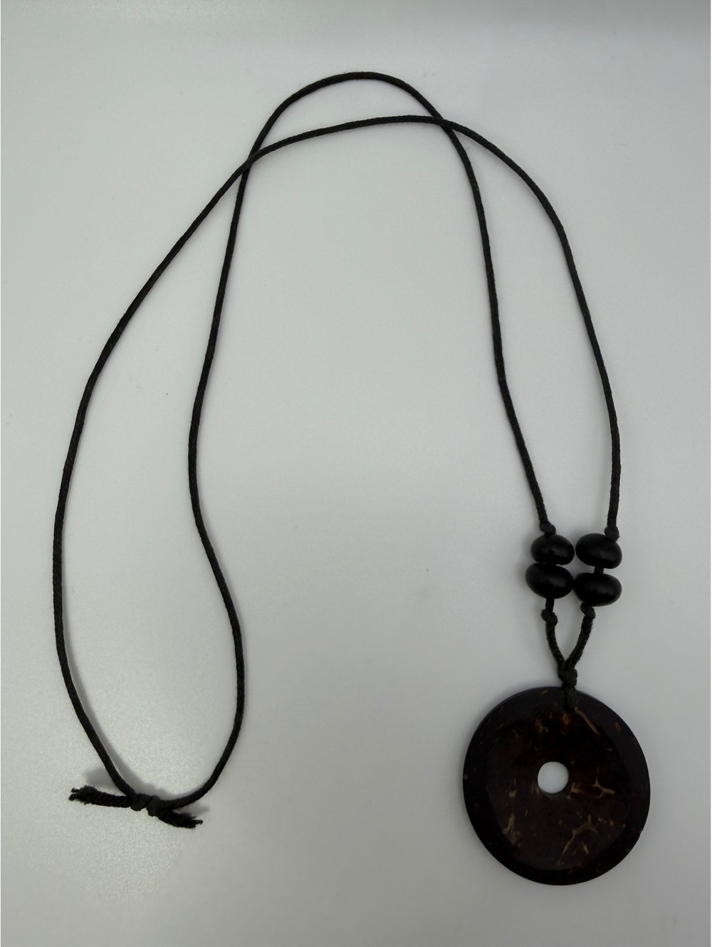 Black cord necklace with round donut pendant